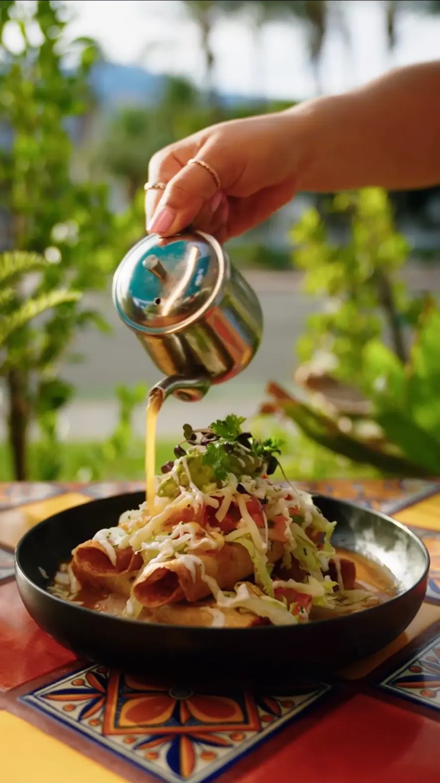 A freshly prepared Felipe’s dish being finished tableside on the patio